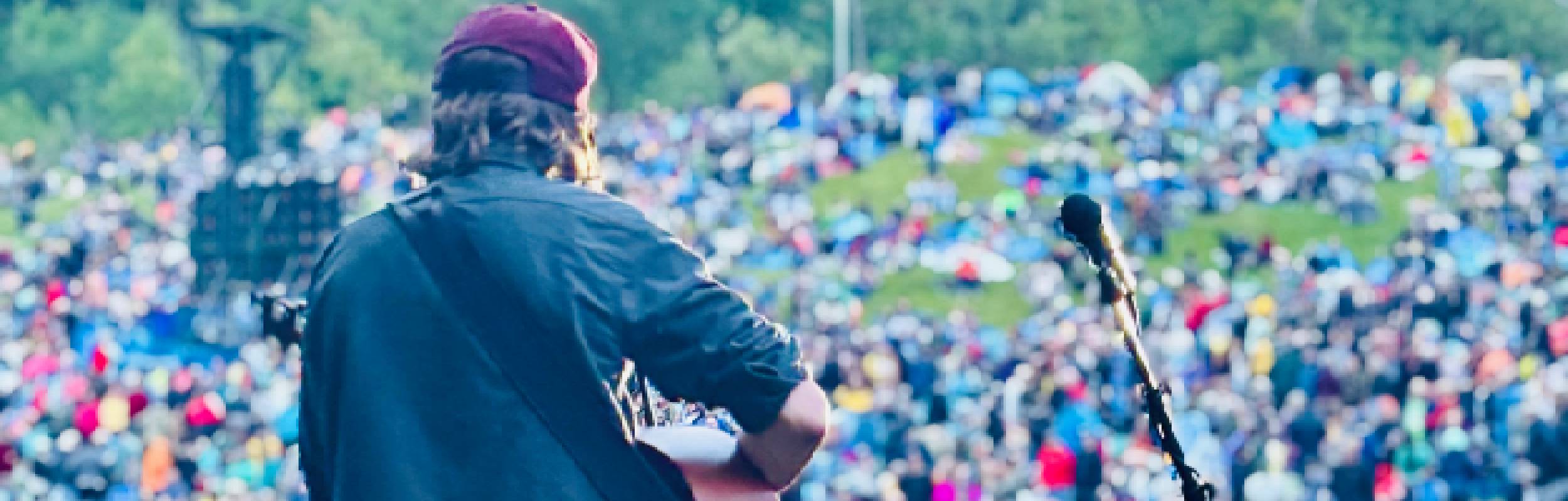 Image of Sam from behind at 2025 Edmonton Folk Music Festival Main Stage